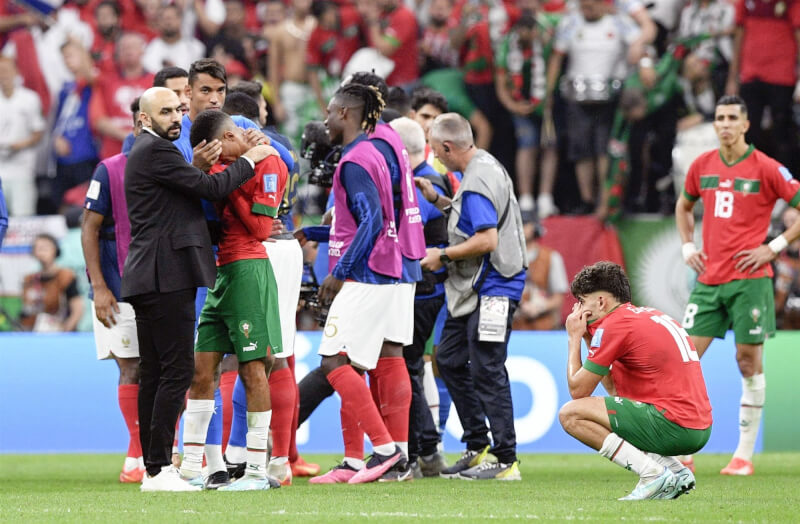 摩洛哥14日在世足4強賽不敵法國，總教練雷格拉吉（前左）安慰球員。（共同社）