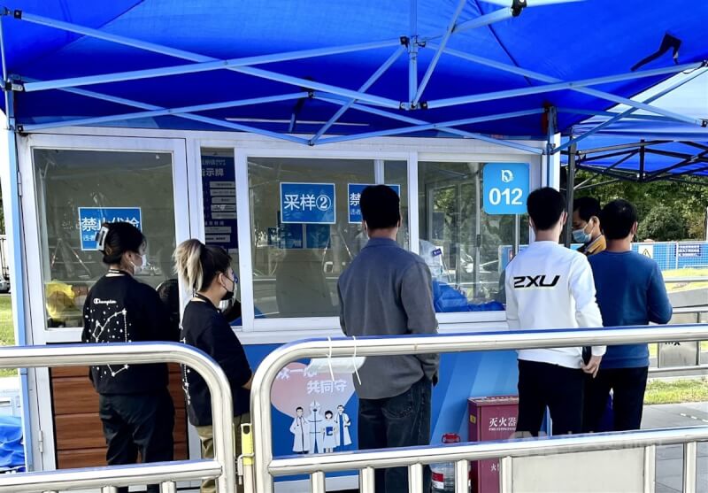 圖為10月12日上海市閔行區一處核酸檢測亭，民眾排隊受檢。（中央社檔案照片）