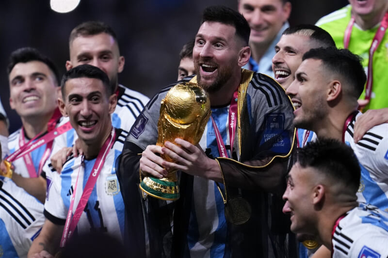 根廷在卡達世足決賽擊敗法國，奪世界盃隊史第3冠，梅西（前中）開心捧金盃。（美聯社）