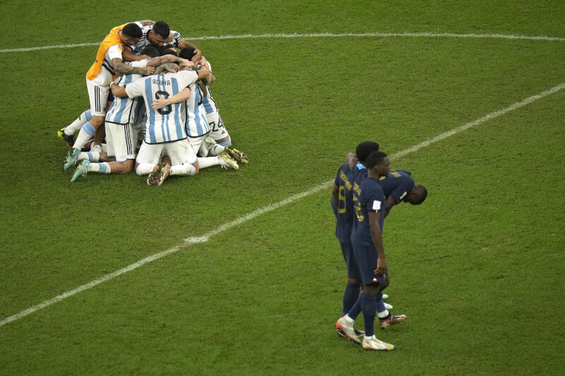 阿根廷在世界盃與法國激戰後，在PK賽以4比2勝出奪下冠軍，阿根廷球員們擁抱慶祝，法國球員難掩失落。（美聯社）
