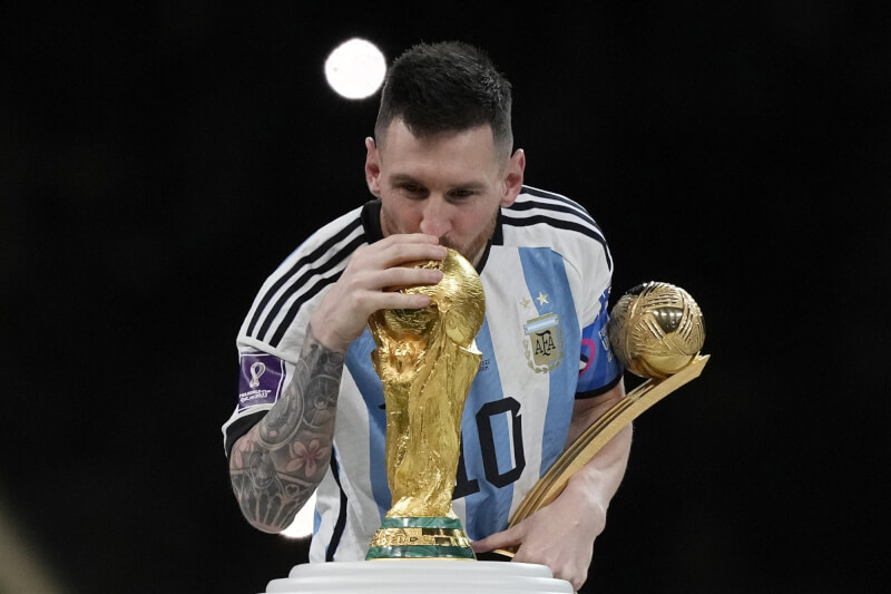 阿根廷在PK戰後擊敗法國，拿下2022卡達世界盃足球賽冠軍，梅西賽後親吻獎盃。（美聯社）