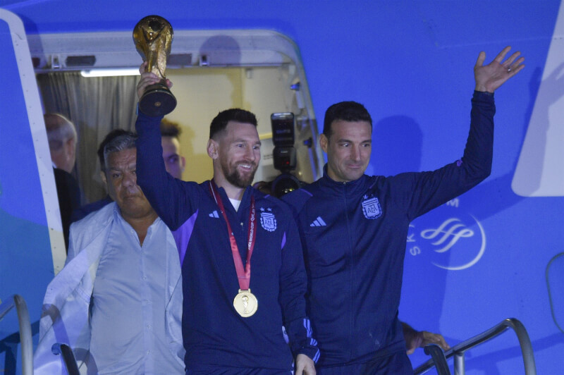 世界盃阿根廷隊奪冠歸國，第一位下機的是拿著冠軍金盃大力神盃的梅西（前左），接著是總教練斯卡洛尼（前右）。（美聯社）