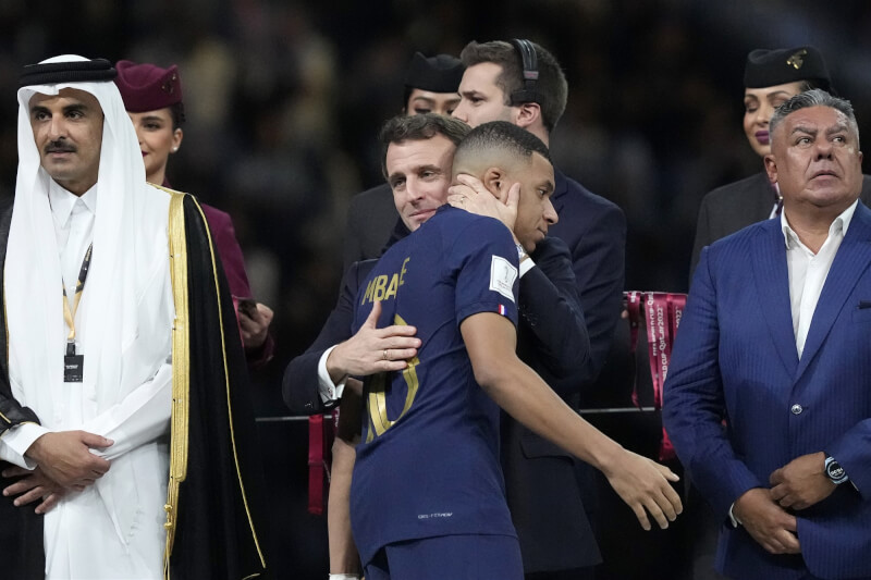 世足決賽法國不敵阿根廷，法國總統馬克宏（前右2）將姆巴佩（前右3）「強擁」入懷安慰，而姆巴佩則反應冷淡。（美聯社）