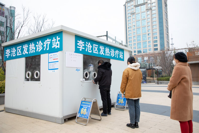 圖為20日山東省青島市民眾在發熱診療站排隊就診。（中新社）