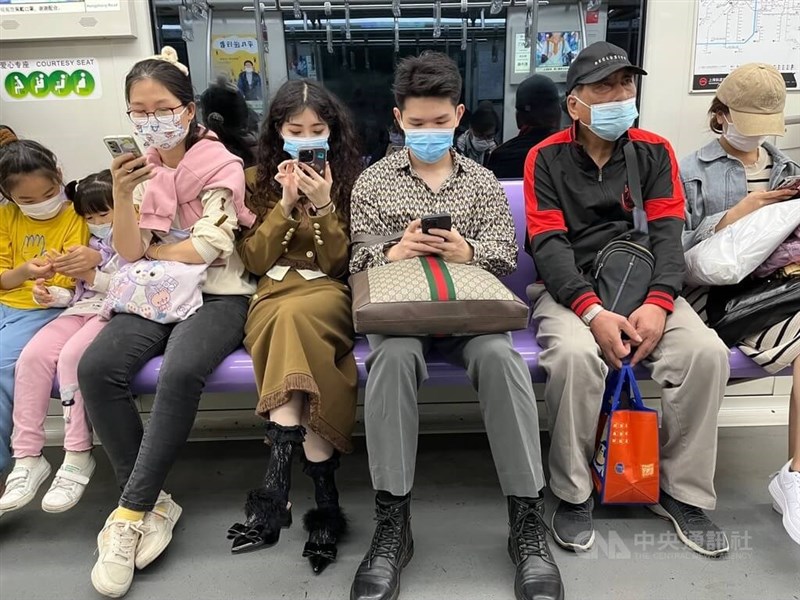 路透社報導，上海德濟醫院估全巿2500萬人口下週末結束前有一半會感染COVID-19。圖為上海市地鐵車廂內，配合防疫要求配戴口罩乘車的旅客。（中央社檔案照片）