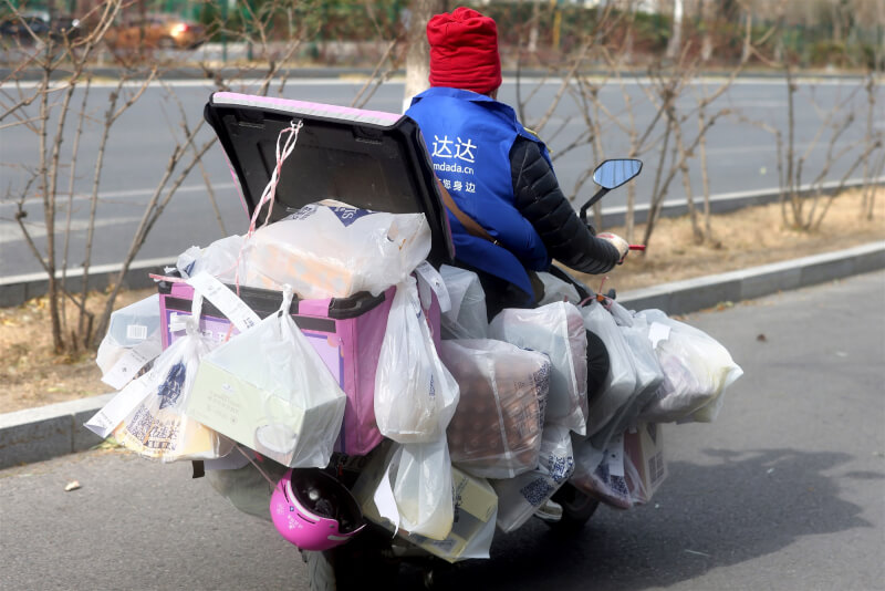 中國疫情蔓延使得許多外送員及快遞司機病倒，多個地方政府鼓勵民眾加入外送行列。圖為北京一名外送員車上載滿物資，準備配送。（中新社）