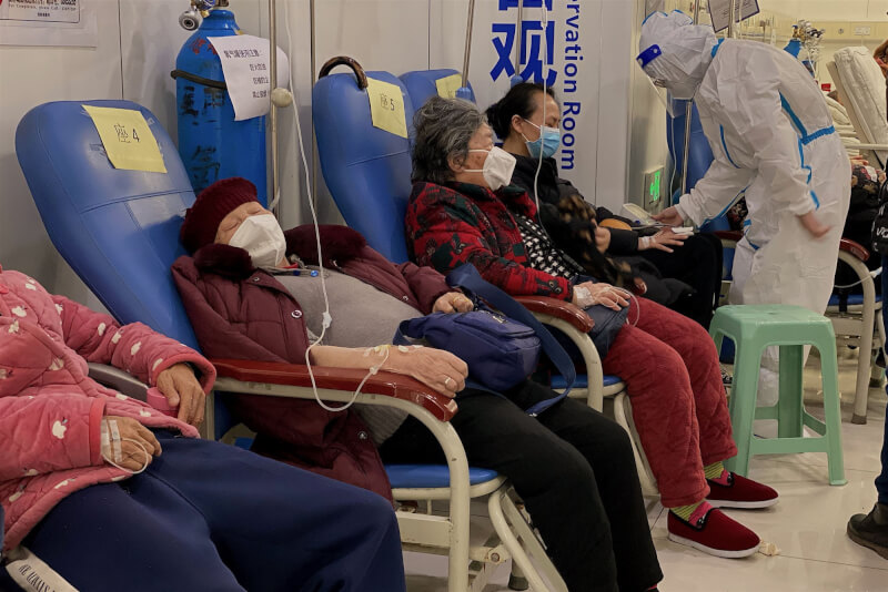中國力抗新一波COVID-19感染潮之際，高齡染疫患者擠滿中國各大城市的醫院，病床一位難求。圖為年長病患在重慶醫科大學附屬第二醫院休息。（法新社）