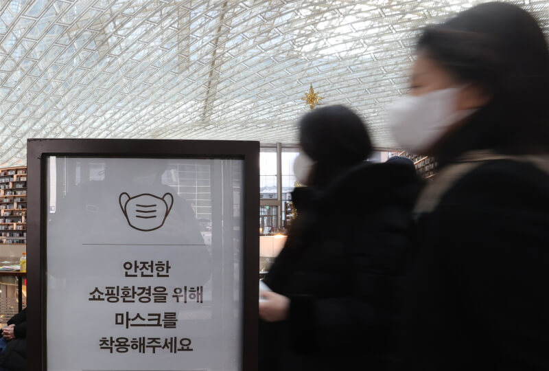 韓國防疫當局23日表示將分階段逐步解除室內戴口罩規定。圖為首爾某大型商場張貼室內佩戴口罩的告示。（韓聯社）