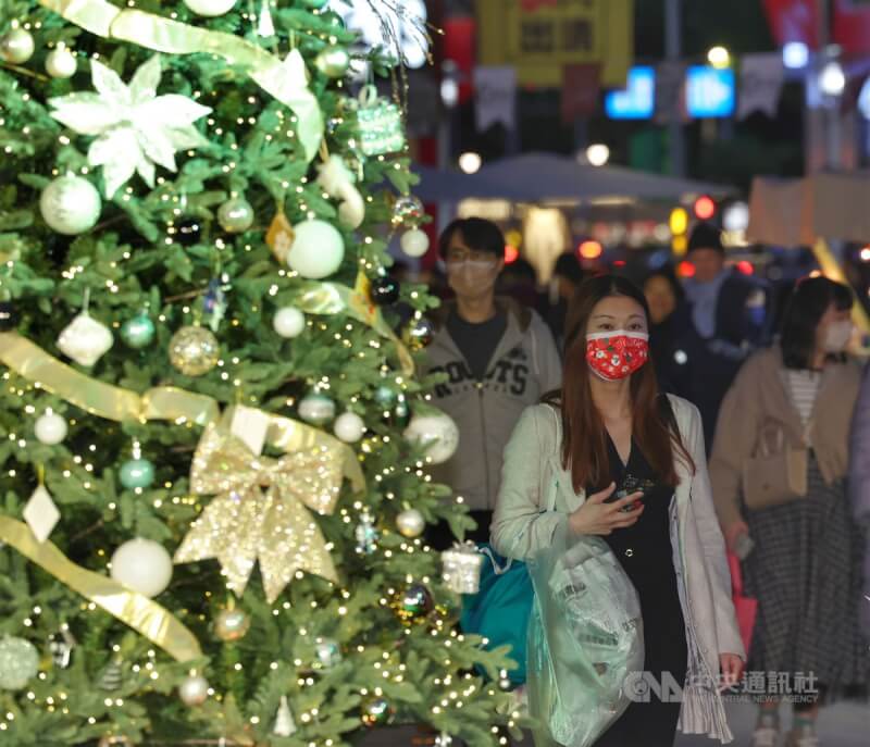 國內25日新增1萬7650例COVID-19本土病例。圖為台北東區商圈有民眾戴上耶誕配色口罩外出。（中央社檔案照片）
