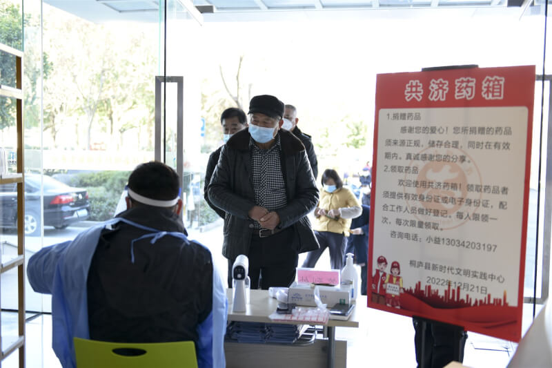圖為23日浙江省杭州市民眾排隊領取捐贈者提供的共濟藥品。（中新社）