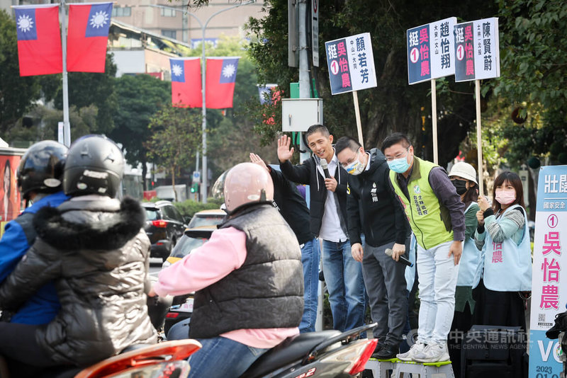 民進黨台北市第3選區立委補選參選人吳怡農（前排右3）26日在台北市議員趙怡翔（前排右2）、陳賢蔚（前排右1）等陪同下，在台北市榮星花園公園附近路口拜票，向來往機車騎士揮手致意。中央社記者王騰毅攝  111年12月26日