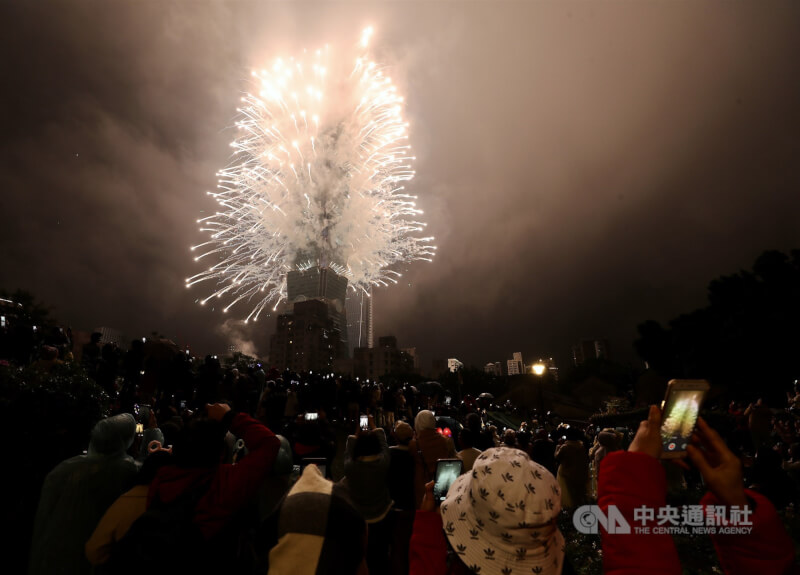 因應本土疫情上升，指揮中心提出跨年等大型活動5項防疫建議，在人潮擁擠戶外仍盡量自主配戴口罩。圖為去年民眾拍下台北101跨年煙火。（中央社檔案照片）