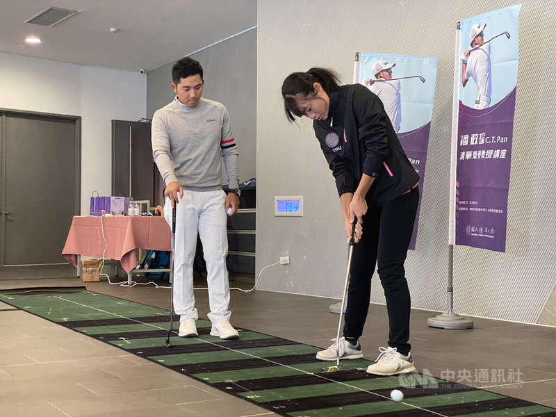 2020東京奧運高爾夫銅牌得主潘政琮（左）27日獲頒國立清華大學榮譽客座教授，並在校內指導學生推桿動作。中央社記者魯鋼駿攝  111年12月27日