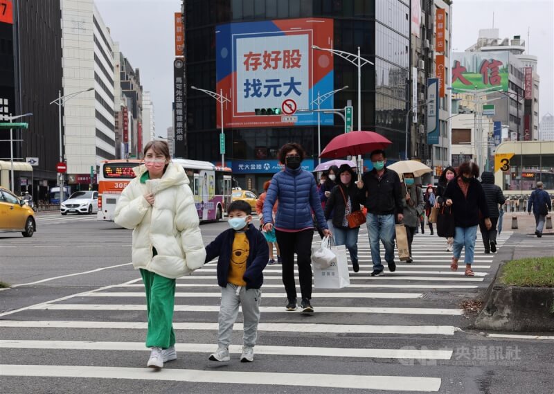 中央氣象局表示，27日各地依舊是晴到多雲天氣，不過基隆北海岸及東半部降雨機率提高。圖為西門町商圈民眾外出穿著厚外套、並撐傘遮擋雨勢。（中央社檔案照片）