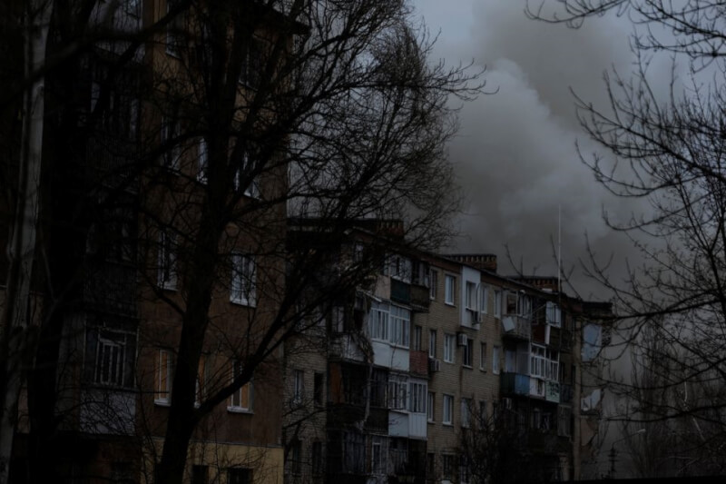 烏克蘭巴赫姆特一棟公寓25日遭到俄軍砲擊，冒出陣陣白煙。（路透社）
