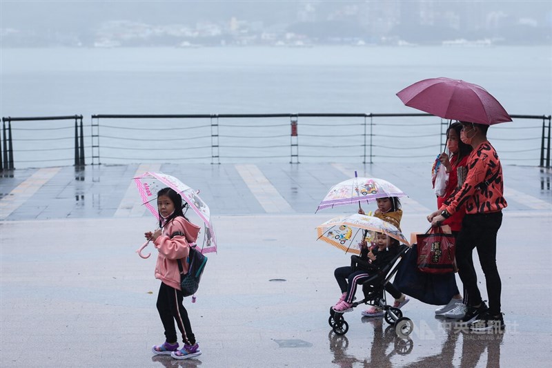 中央氣象局表示，28日桃園以北及東半部有局部短暫雨。圖為民眾撐傘走在淡水老街。（中央社檔案照片）