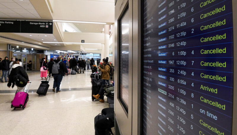 美國「世紀暴風雪」27日持續影響紐約州和全國空中客運運輸，並有數以千計家戶仍然斷電。圖為22日在芝加哥中途國際機場等待搭機的旅客。（路透社）