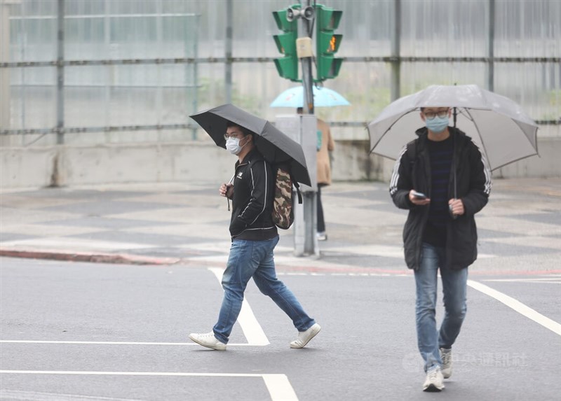 圖為台北市信義區民眾撐傘遮擋雨勢。中央社記者張新偉攝 111年12月29日