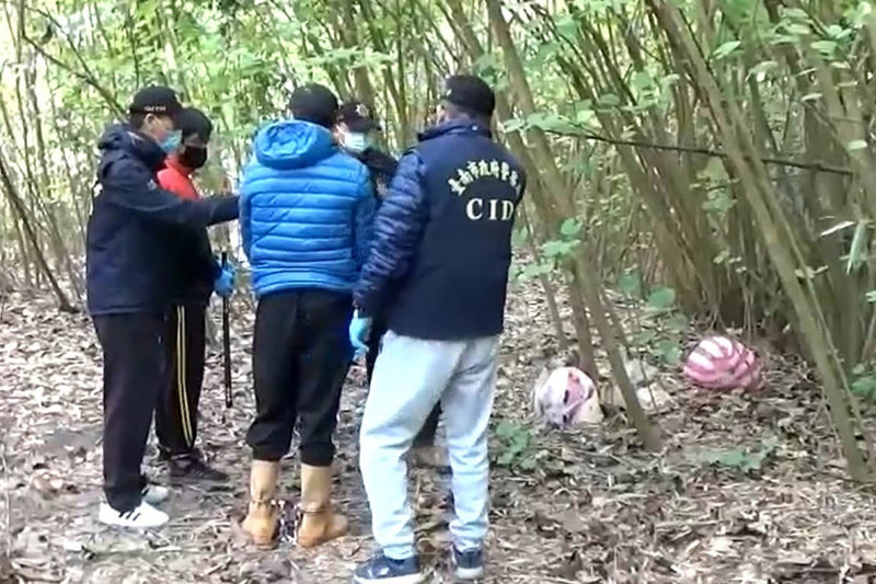 台南警方今年7月接獲民眾通報在新化山區發現白骨，追查發現為台中市失蹤人口22歲陳姓女子，追查後於28日拘提死者前男友王姓男子（前中）等2嫌到案，並帶回現場釐清案情。（讀者提供）中央社記者楊思瑞台南傳真  111年12月29日