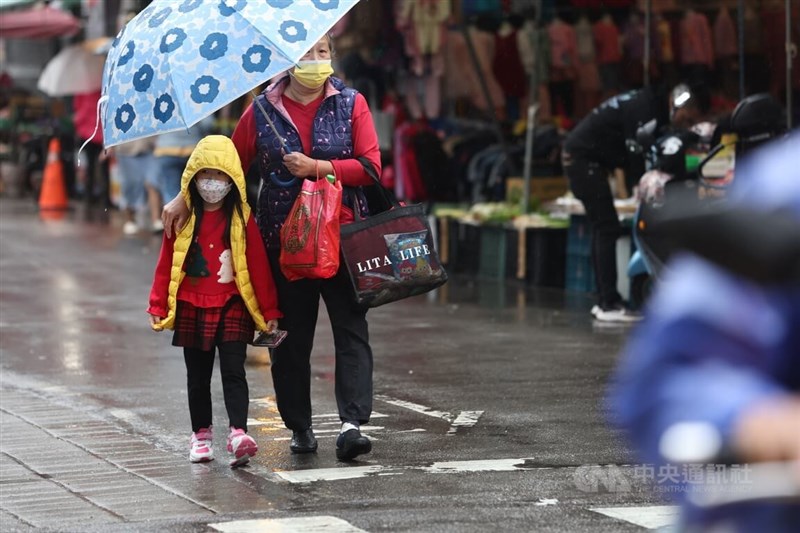 氣象局29日發布大雨特報，基隆市、新北市及宜蘭縣防大雨。圖為民眾帶著小朋友撐傘到新北市蘆洲區一處傳統市場採買。（中央社檔案照片）