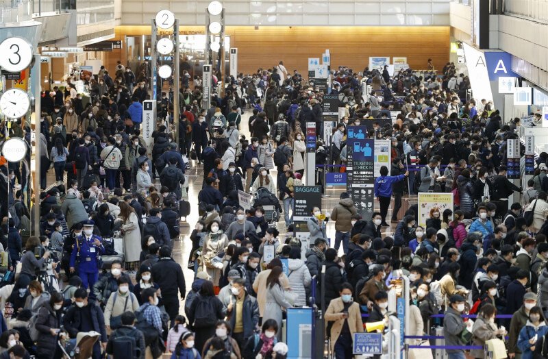 日本即將迎接新年假期，當局放寬COVID-19防疫限制，29日陸空交通湧現大量返鄉出遊人潮。圖為29日羽田機場人潮。（共同社）