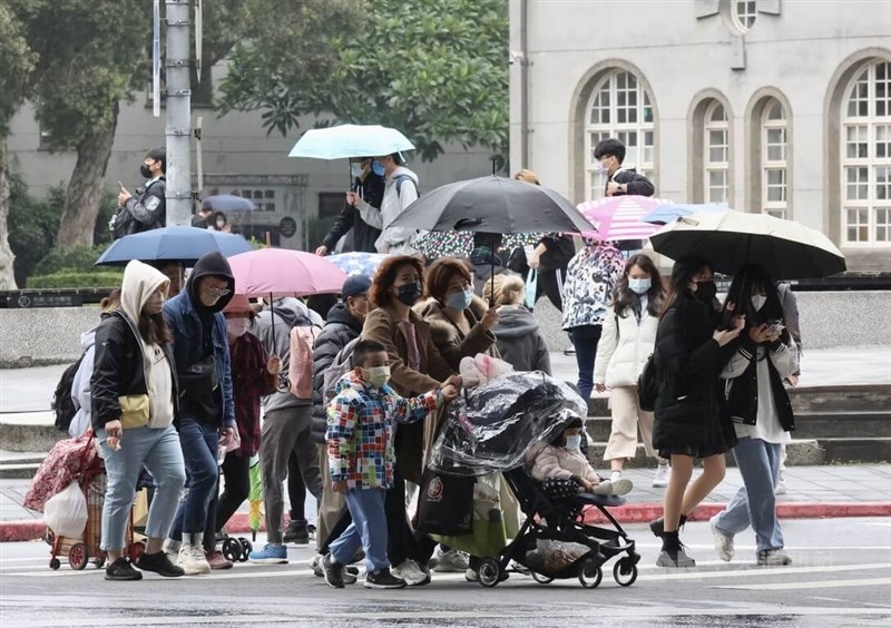圖為31日北市中正區街頭的民眾撐傘遮雨。中央社記者張皓安攝 111年12月31日