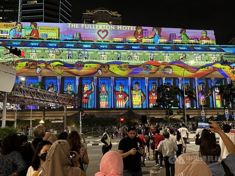 揮別疫情陰霾，新加坡濱海灣跨年活動盛大回歸。活動包括投映在富麗敦飯店外牆的投影秀，訴說民眾行善小故事。中央社記者侯姿瑩新加坡攝 112年1月1日