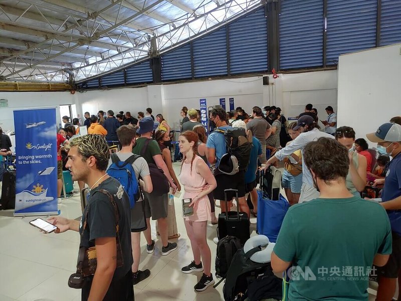 菲律賓首都馬尼拉國際機場1日因技術問題導致全國空中交通大癱瘓,影響逾5.6萬名旅客。圖為巴拉旺省(Palawan)布桑加機場(Busuanga)各國旅客焦急排隊詢問航班變更和機票問題。中央社記者陳妍君布桑加鎮攝 112年1月1日
