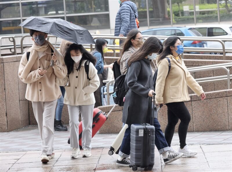 圖為台北市中正區民眾撐傘遮雨。（中央社檔案照片）