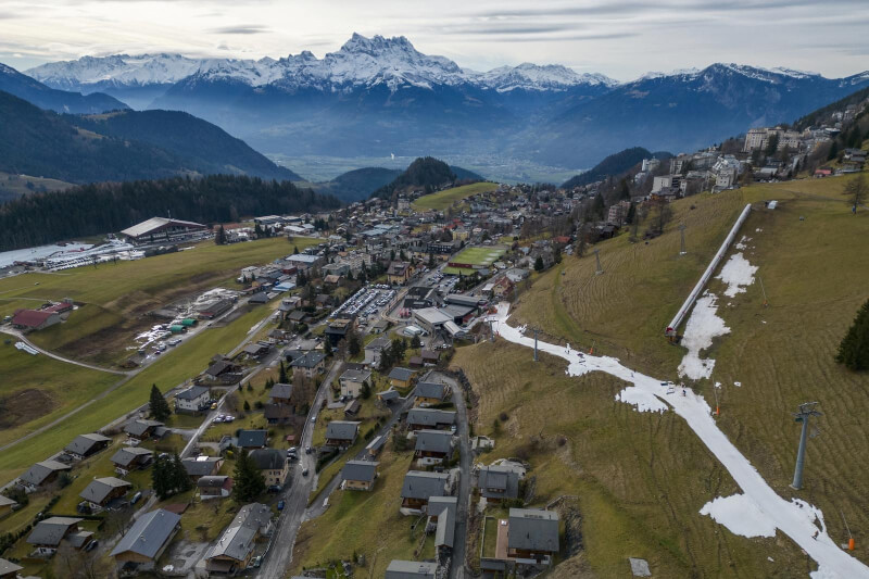 圖為瑞士冬季氣溫異常，滑雪客4日在阿爾卑斯山度假勝地萊森只能在一層人造雪上行走。（路透社）