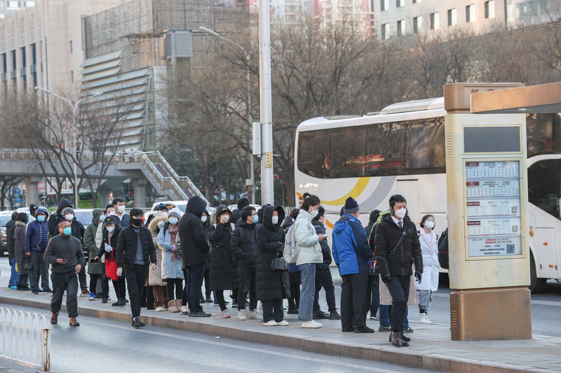 北京市當局6日說，當地疫情態勢已經趨緩，門診急診病患數已從最高峰明顯下降。圖為3日，北京迎來2023年第一個工作日，上班人潮明顯增加，在公車站排出長龍。（中新社提供）中央社  112年1月6日