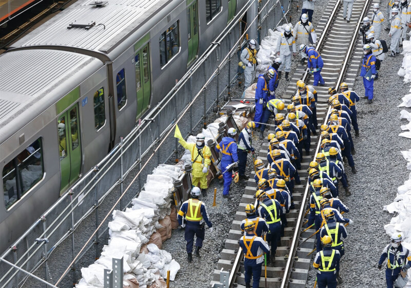 日本東京澀谷車站周邊大規模都更，車站內部近日正進行改善工程，總計動員約4000名作業人員，以手工拆除月台並將鐵軌外移。圖為7日作業人員施工情形。（共同社）