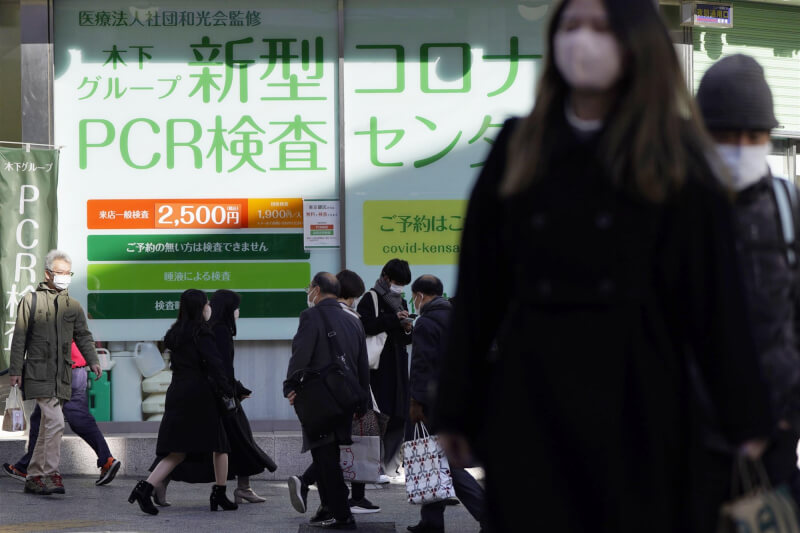 日本第8波COVID-19疫情肆虐造成死亡病例激增，從2022年12月以來的一個多月間，全境至少已有超過一萬人病故。圖為東京新橋行人戴著口罩走在路上。（共同社）