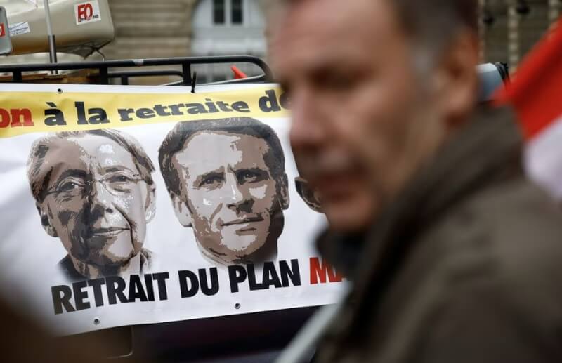 法國民眾10日在街上橫掛印有總理柏納、總統馬克宏的布條，抗議政府的退休金改革計畫。（路透社）