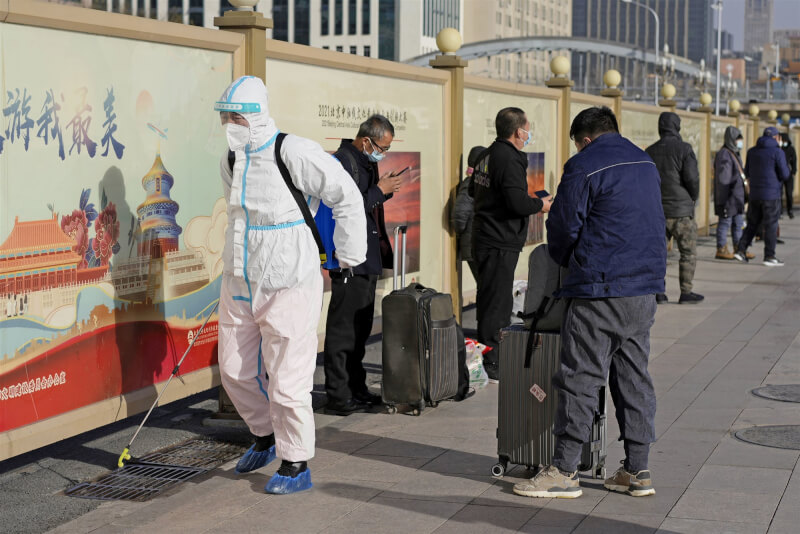 彭博報導，中國已連續3天未更新COVID-19感染數據。圖為穿著防護衣的工作人員6日在北京車站前廣場消毒。（共同社）