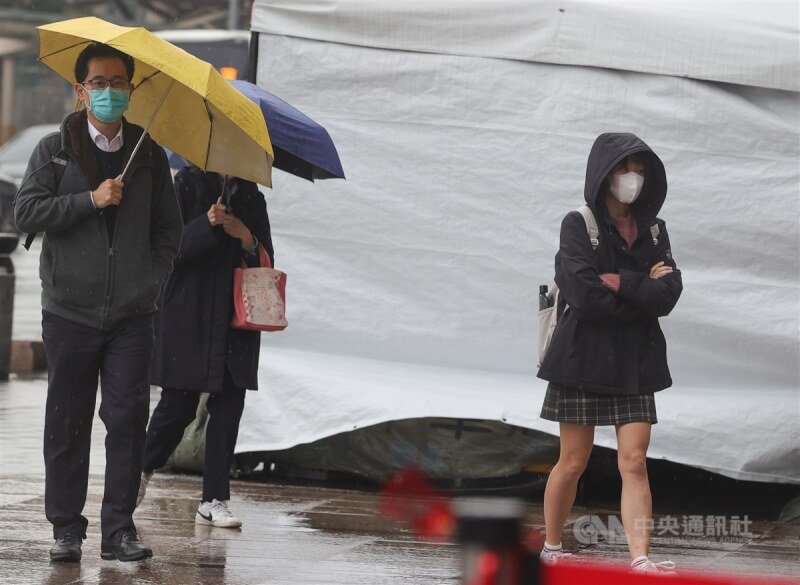 中央氣象局說，14日晚上起鋒面通過，北台灣降雨機率提高，雨勢轉趨明顯，其他地區也有局部短暫陣雨。圖為台北市中正區街頭民眾撐傘或戴上帽子擋雨。（中央社檔案照片）