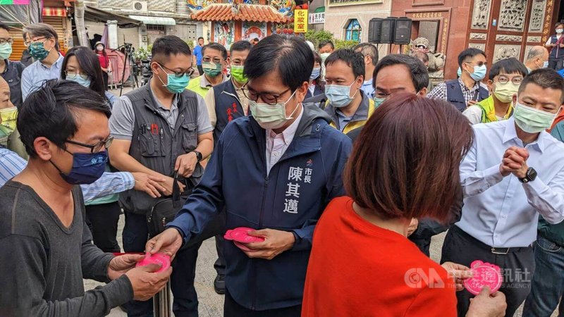 高雄市長陳其邁（中）14日行程滿檔，除到廟宇參香，也到商圈推廣「高雄過好年」活動，並在各點發放小紅包，向市民拜早年，吸引不少民眾排隊領取。中央社記者曾以寧攝  112年1月14日