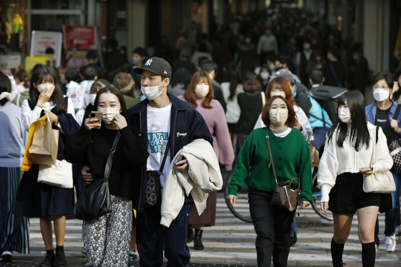 圖為行人戴著口罩步行在大阪南區。（共同社）