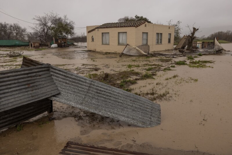 美國國家氣象局預測薩利納斯河流域下游將發生「災難性洪水」。圖為14日薩利納斯河旁一棟房屋遭洪水淹沒。（法新社）