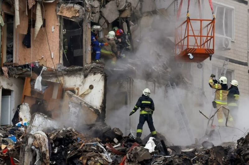 俄羅斯15日襲擊烏克蘭第聶伯羅市公寓，救難人員協助民眾逃出。（路透社）
