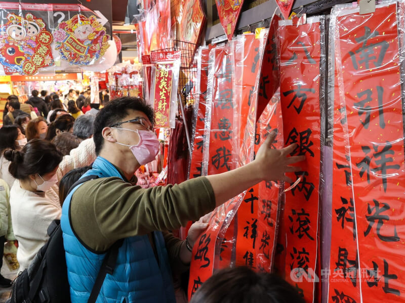 圖為民眾在台北南門市場採買年貨並選購春聯。（中央社檔案照片）