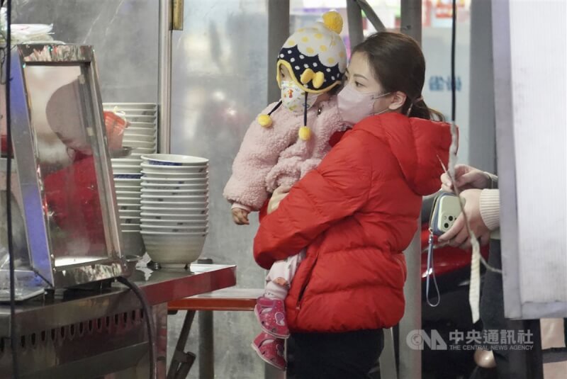 強烈大陸冷氣團影響，中央氣象局17日上午發布新北、桃園等6縣市低溫特報及燈號。圖為高雄市鳳山區民眾穿著厚實冬衣禦寒。（中央社檔案照片）