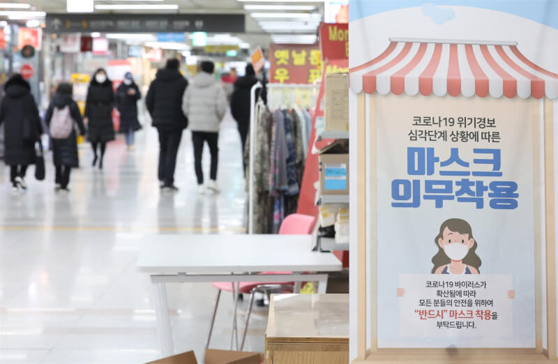 韓國20日宣布，1月30日起解除在大多數室內公共場所須戴口罩的規定，但搭乘交通運輸工具與出入醫療設施仍須戴上口罩。圖為首爾一家購物中心張貼戴口罩告示。（韓聯社）
