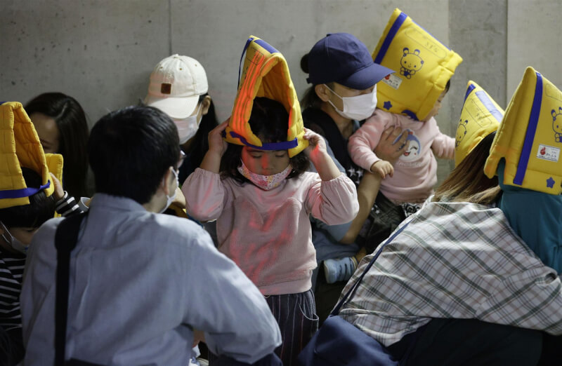 日本21日針對「假想國」發動彈道飛彈攻擊，首度在沖繩縣那霸市舉行居民飛彈避難訓練。圖為民眾帶孩子到地下室避難。（共同社）