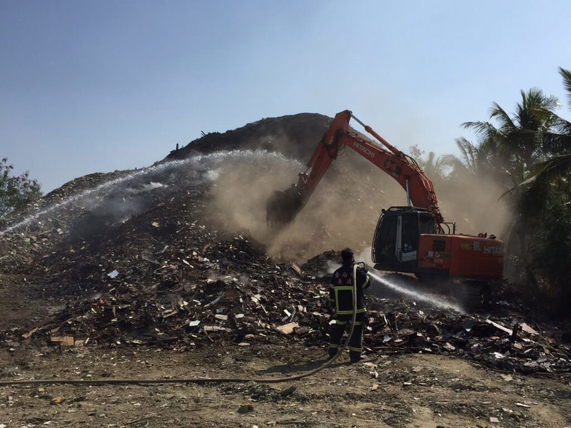 台南市安南區海西段空地大量廢木材25日發生大火，濃煙密布，台南市消防局趕往灌救控制，環保局將對行為人開罰及移送法辦。（台南市政府提供）中央社記者張榮祥台南傳真  112年1月25日