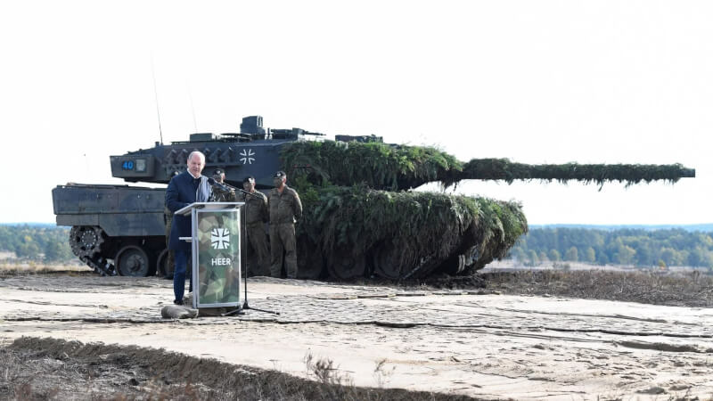 圖為德國總理蕭茲（前）去年10月拜訪德國聯邦國防軍時，在豹2戰車（後）前發表演說。（路透社）