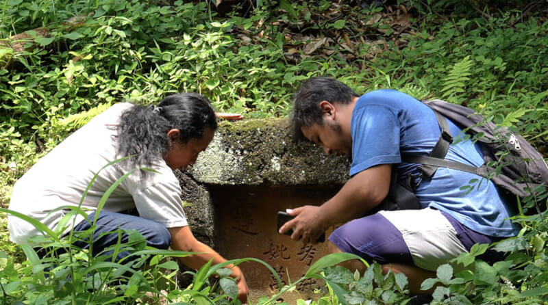 奧古斯托（左）與路沙卡（右）在印尼三寶瓏市郊的一處樹林找到一座華人墳墓。中央社記者李宗憲三寶瓏攝 112年1月26日
