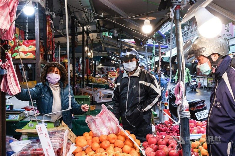 圖為新北市蘆洲區民眾前往菜市場採買水果，儘管戶外口罩政策已鬆綁一段時間，民眾外出仍維持戴口罩的習慣。（中央社檔案照片）