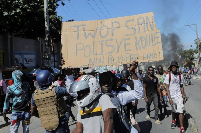 海地一名示威者26日手舉寫著「警察的鮮血太多了。我們不能再忍受了」的標語，抗議近期多名警察遭殺害。（路透社）