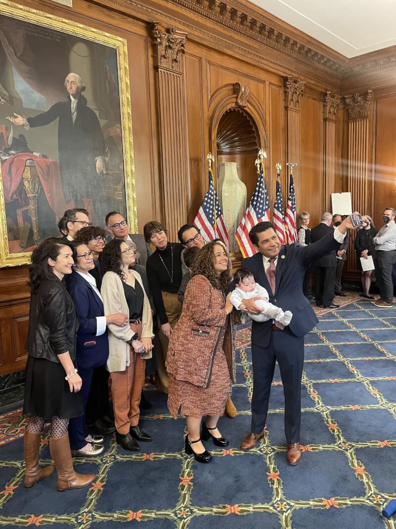 美國眾議員葛梅茲（右）月初抱著兒子穿梭在國會議場間，不少議員還趁著空檔時間，上前逗弄小孩。（圖取自facebook.com/RepJimmyGomez）